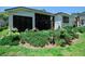 Landscaped backyard featuring lush greenery, string lights, and a covered patio for outdoor living at 3506 Cordgrass Dr, Valrico, FL 33596