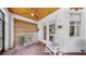 Cozy covered lanai with brick flooring, ceiling fan, white rocking chairs, and french doors leading inside at 3506 Cordgrass Dr, Valrico, FL 33596