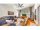 Bright living room with hardwood floors, ceiling fan, blue sofa, and large window at 3506 Cordgrass Dr, Valrico, FL 33596