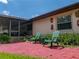 Cozy back patio with matching green Adirondack chairs on a bright, sunny day at 37821 Willingham Ave, Dade City, FL 33525