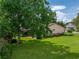 Large backyard with mature trees providing ample shade and a view of neighboring homes at 37821 Willingham Ave, Dade City, FL 33525