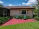 Exterior back of house featuring a screened in lanai, lush landscaping and two green chairs at 37821 Willingham Ave, Dade City, FL 33525