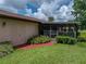 Backyard featuring a screened lanai, lush landscaping and a red brick walkway at 37821 Willingham Ave, Dade City, FL 33525
