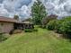 Wide shot of backyard featuring lush landscaping and a screened lanai at 37821 Willingham Ave, Dade City, FL 33525