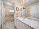 Neutral bathroom with a white vanity, white tile flooring, and grab bars for accessibility at 37821 Willingham Ave, Dade City, FL 33525