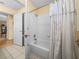 Bathroom featuring a tiled shower and tub combination with decorative shower curtain at 37821 Willingham Ave, Dade City, FL 33525