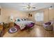 Cozy bedroom with a floral bedspread, a ceiling fan, and plush seating at 37821 Willingham Ave, Dade City, FL 33525