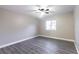 A sunlit bedroom with wood-look flooring, a ceiling fan, and large window, offering a serene space at 3805 Cortez Cir # B, Tampa, FL 33614