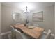 Dining room featuring wood table, modern chandelier, light walls, and round mirror at 3805 Cortez Cir # B, Tampa, FL 33614