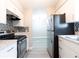 Galley kitchen featuring stainless steel appliances, white cabinets, and mosaic backsplash at 3805 Cortez Cir # B, Tampa, FL 33614