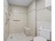 Accessible bathroom with a tiled shower, including a supportive grab bar, shower seat, and handheld shower head at 384 Boca Ciega Point Blvd, St Petersburg, FL 33708