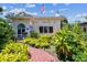 Charming home with a brick walkway and verdant landscaping beneath a clear, blue sky with white, puffy clouds at 4435 1St S Ave, St Petersburg, FL 33711