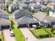 Aerial view of a gray home with a large driveway, patio, and well-manicured lawn in a suburban neighborhood at 4465 Tubular Run, Land O Lakes, FL 34638