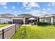 Fenced backyard with a covered patio, outdoor seating and lush green grass at 4465 Tubular Run, Land O Lakes, FL 34638