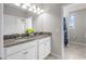 Bathroom with double granite vanity, modern lighting, white cabinets, and tiled floors at 4465 Tubular Run, Land O Lakes, FL 34638