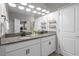 Bright bathroom featuring a double vanity with granite countertops and modern fixtures, plus a view into an adjoining bedroom at 4465 Tubular Run, Land O Lakes, FL 34638
