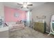Cozy bedroom with pink walls, a twin bed with storage underneath, and a bright window with curtains at 4465 Tubular Run, Land O Lakes, FL 34638