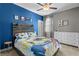 Bedroom with blue accent wall, sports themed bedding, and a white dresser next to the window at 4465 Tubular Run, Land O Lakes, FL 34638
