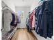 Walk-in closet featuring custom shelving and hardwood floors with clothing neatly arranged on both sides at 4465 Tubular Run, Land O Lakes, FL 34638