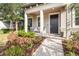 Close-up of a charming front porch with a seating area, well-manicured landscaping, and a welcoming entrance at 4465 Tubular Run, Land O Lakes, FL 34638