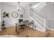 Bright office featuring a decorative ceiling light, wood desk, stairs, and wood floors and a decorative clock at 4465 Tubular Run, Land O Lakes, FL 34638