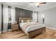 Relaxing main bedroom featuring a wood accent wall, and large windows with natural light and wood floors at 4465 Tubular Run, Land O Lakes, FL 34638