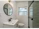 This bathroom features light green tile, a modern round mirror and a walk-in shower with a glass door at 463 85Th Ave, St Pete Beach, FL 33706
