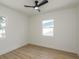 This bedroom features a ceiling fan, two windows and light wood floors at 463 85Th Ave, St Pete Beach, FL 33706
