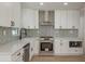 Modern kitchen featuring white cabinets, stainless steel appliances, and a stylish backsplash at 463 85Th Ave, St Pete Beach, FL 33706