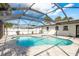 This home features an in-ground pool under a large screened enclosure and a stone paver pool deck at 463 85Th Ave, St Pete Beach, FL 33706