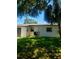 Exterior of home showcasing grassy backyard with mature trees and AC unit at 5627 Commonwealth N Ave, St Petersburg, FL 33703