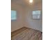 Bright bedroom with wood-look flooring, featuring two windows and ample natural light at 5627 Commonwealth N Ave, St Petersburg, FL 33703