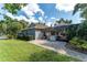 This backyard features a screened lanai, brick pavers, lush green lawn, and mature trees for privacy at 5927 Flatwoods Manor Cir, Lithia, FL 33547