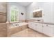 Bright bathroom features a soaking tub with tile surround and a window letting in natural light at 5927 Flatwoods Manor Cir, Lithia, FL 33547