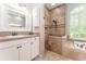 Bathroom featuring dual vanities, a walk-in shower, and a soaking tub at 5927 Flatwoods Manor Cir, Lithia, FL 33547