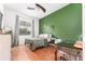 Cozy bedroom with hardwood floors, a green accent wall, and a study desk at 5927 Flatwoods Manor Cir, Lithia, FL 33547