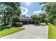 Spacious driveway leading to a multi-car garage and basketball court with greenery at 5927 Flatwoods Manor Cir, Lithia, FL 33547