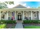 Charming home entrance featuring detailed millwork, rocking chairs and manicured landscaping at 5927 Flatwoods Manor Cir, Lithia, FL 33547