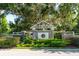 Community entrance featuring a stone monument, lush landscaping, and mature trees at 5927 Flatwoods Manor Cir, Lithia, FL 33547