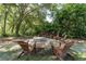 Enjoy this backyard fire pit with Adirondack chairs, surrounded by lush greenery and a stone fire pit at 5927 Flatwoods Manor Cir, Lithia, FL 33547