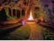 Gather around this backyard fire pit with Adirondack chairs and brick paver pathway for cozy evenings at 5927 Flatwoods Manor Cir, Lithia, FL 33547