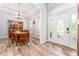 Bright foyer with decorative front door, beautiful floors, and views of dining area at 5927 Flatwoods Manor Cir, Lithia, FL 33547