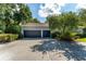This home features a spacious two car garage and wide driveway, with mature trees adding shade at 5927 Flatwoods Manor Cir, Lithia, FL 33547