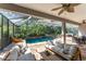 Enjoy the luxury of this screened pool with stone waterfall, outdoor seating, and adjacent dining area at 5927 Flatwoods Manor Cir, Lithia, FL 33547