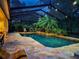 Enclosed pool area with mature landscaping, stone flooring, and lounge chairs at 5927 Flatwoods Manor Cir, Lithia, FL 33547