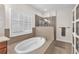 Bright bathroom showcases a standalone tub with tiled trim and a glass enclosed shower at 6207 Bleeker St, Riverview, FL 33578