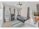 Charming bedroom featuring a twin bed, colorful ceiling fan, and natural light from two shuttered windows at 6207 Bleeker St, Riverview, FL 33578