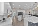 Open-concept kitchen with white cabinets, island, stainless steel appliances, and seamless flow to living areas at 6207 Bleeker St, Riverview, FL 33578