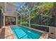 A narrow pool is enclosed in a screen, surrounded by tropical landscaping for privacy and relaxation at 6207 Bleeker St, Riverview, FL 33578