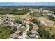 An aerial shot showcases the single story home with lush trees, a large yard, and a serene neighborhood at 6351 Desert Peace Ave, Land O Lakes, FL 34639